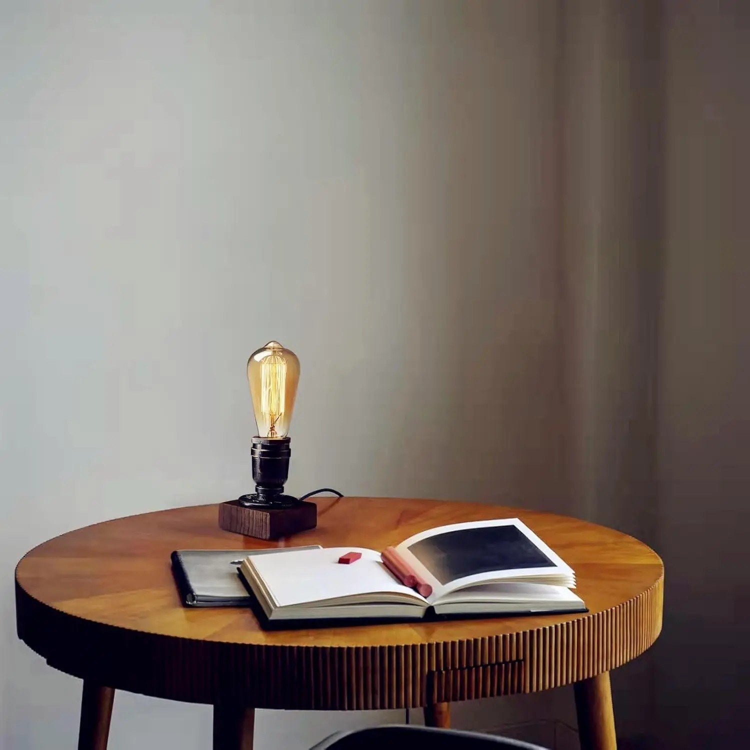 Lampe de bureau vintage allumée sur une table ronde avec des livres