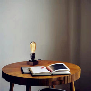 Lampe de bureau vintage allumée sur une table ronde avec des livres