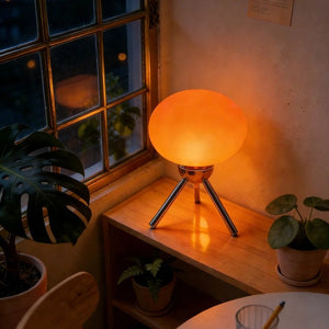 Lampe de chevet champignon en verre rouge allumée avec une lueur chaude