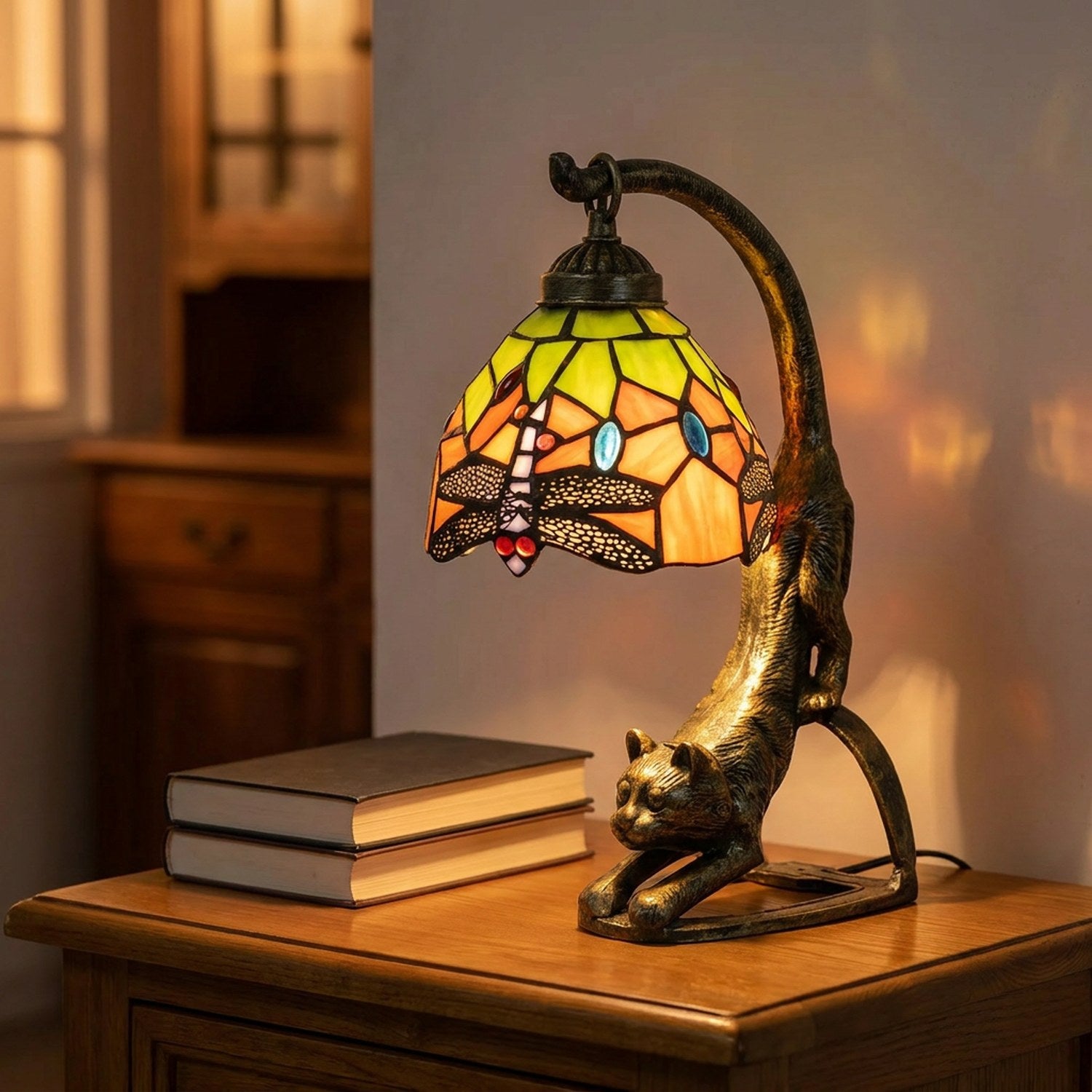 Lampe chat en vitrail façon Tiffany allumée sur une table de chevet en bois