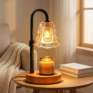 Lampe chauffe-bougie fleur ambrée dans un coin lecture près d'un fauteuil avec un plaid et des livres
