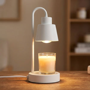 Lampe chauffe-bougie blanche allumée en gros plan avec bougie parfumée