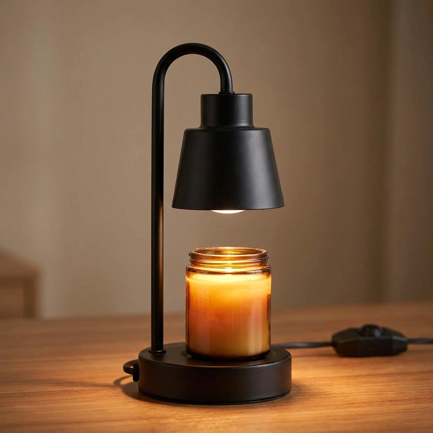 Lampe chauffe-bougie noire allumée en gros plan avec bougie parfumée