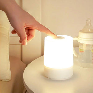 Doigt qui touche le bouton tactile au sommet de la lampe allumée