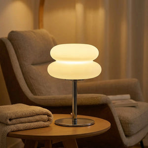 Lampe de chevet galet allumée près d'un fauteuil de lecture