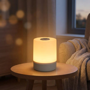 Lampe de chevet tactile allumée sur une table basse près d'un fauteuil cocooning