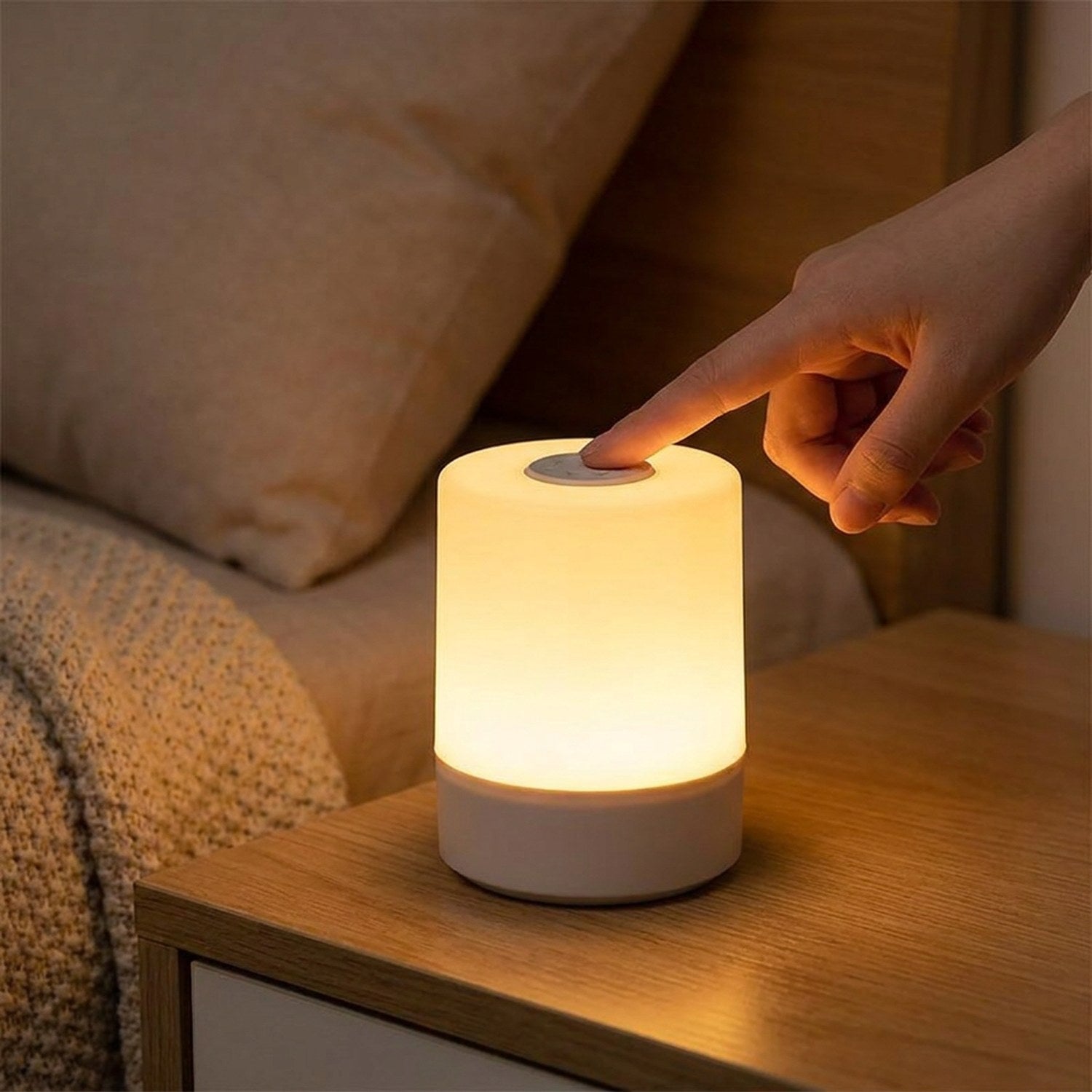 Main effleurant le bouton tactile de la lampe de chevet allumée la nuit