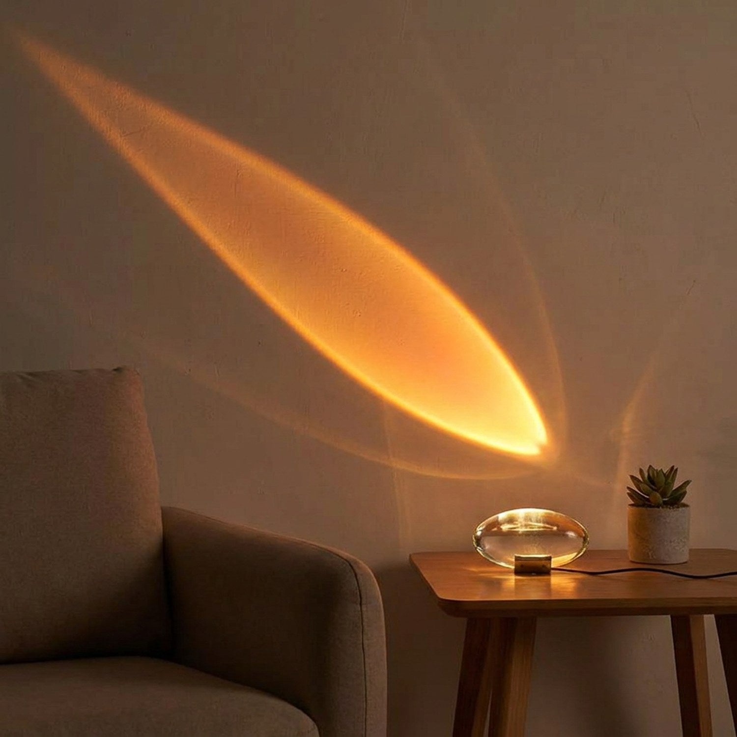 Lampe cristal projetant un halo orange coucher de soleil près d'un fauteuil et d'une plante