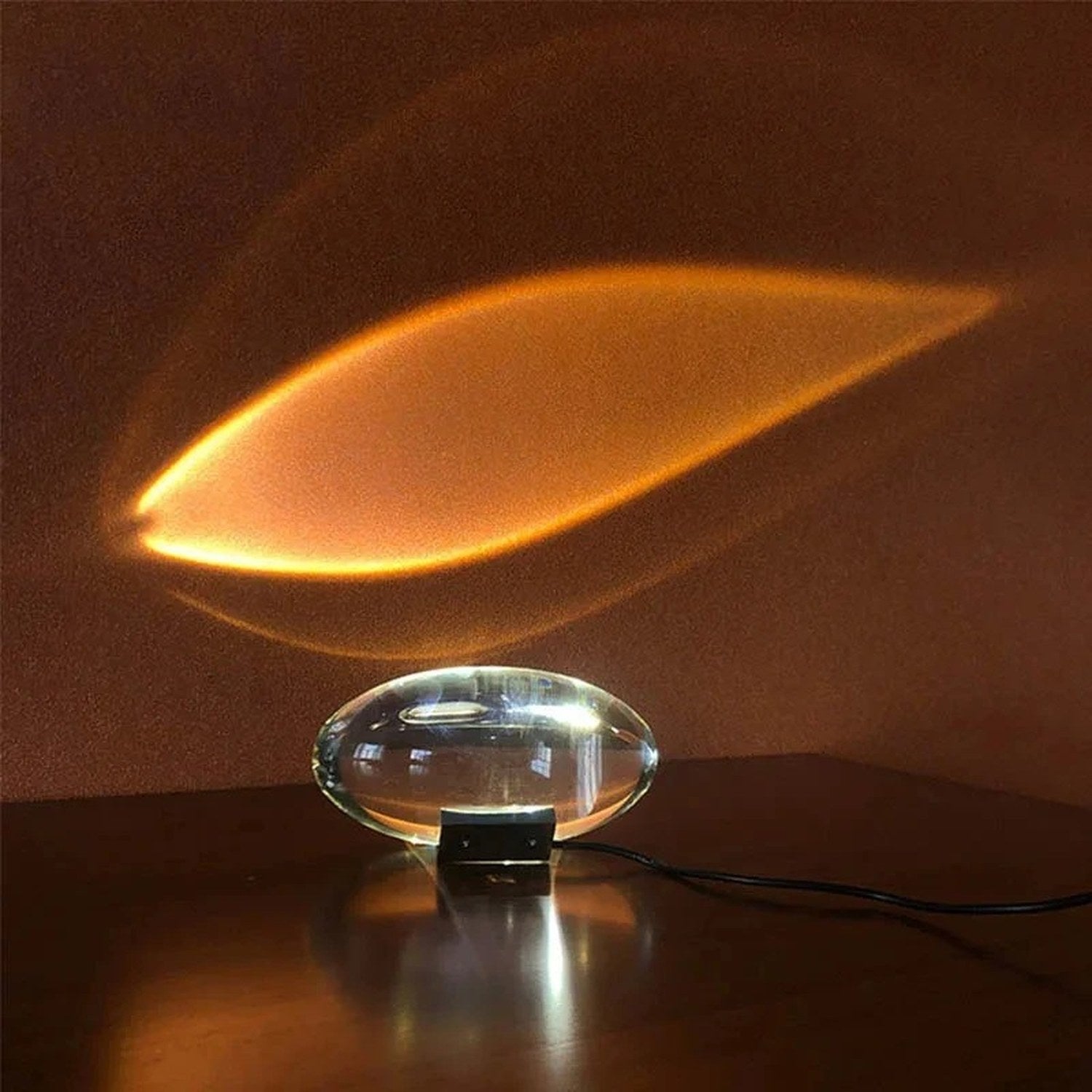 Lampe cristal avec son câble d'alimentation posée sur une table en bois