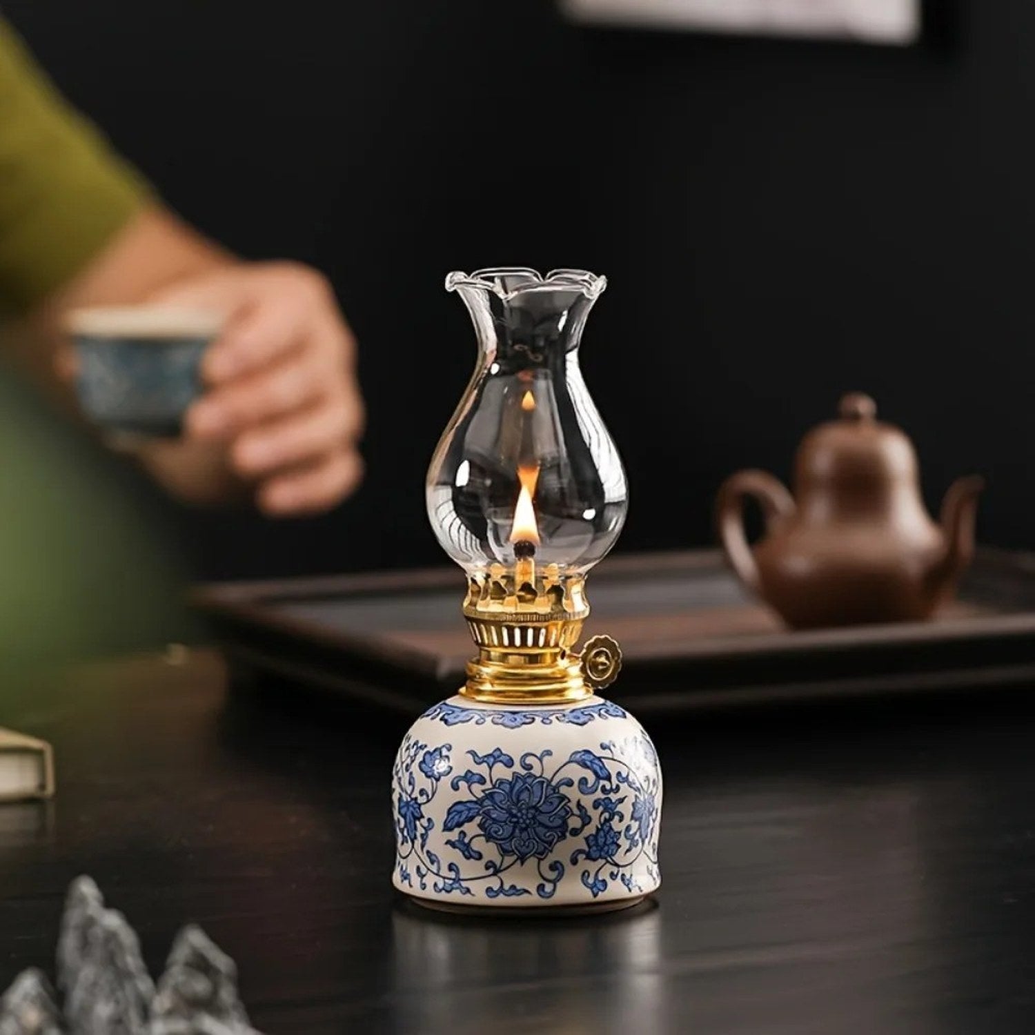Lampe à huile vintage céramique posée près d'un service à thé traditionnel