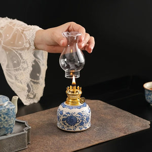 Main posant la cheminée en verre sur la lampe à huile vintage allumée