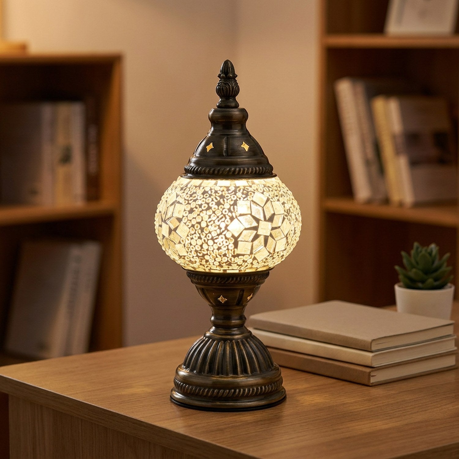 Lampe de table mosaïque allumée sur un bureau en bois avec livres et plante