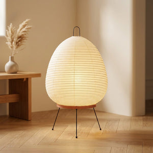 Lampe style Noguchi en papier de riz washi posée dans un salon aux tons beige et naturels
