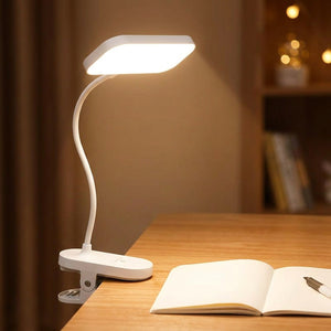 Lampe à pince LED allumée sur un bureau près d un carnet ouvert pour lire le soir