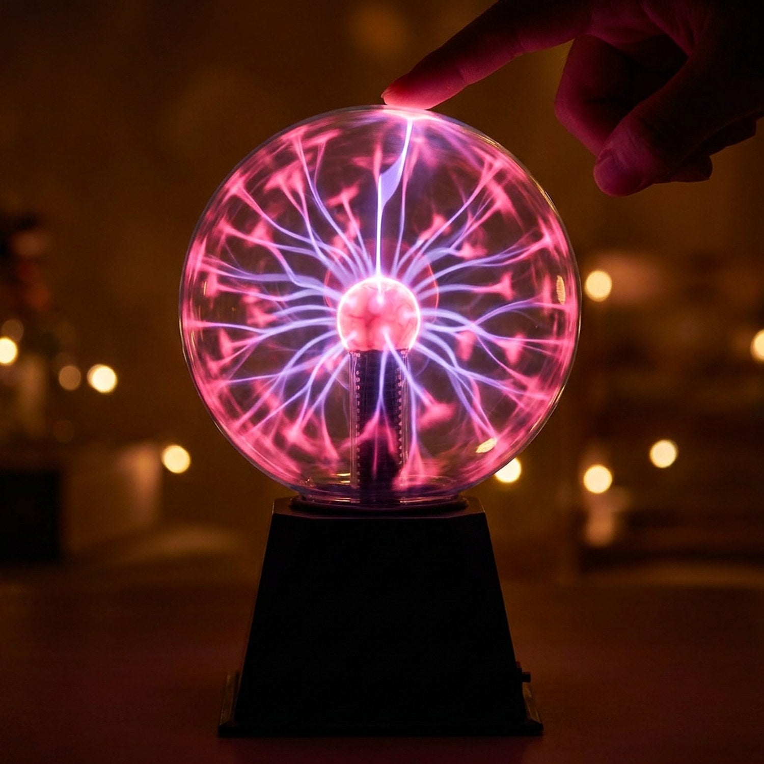 Boule de verre lumineuse aux filaments violets et roses touchée du doigt sur fond sombre