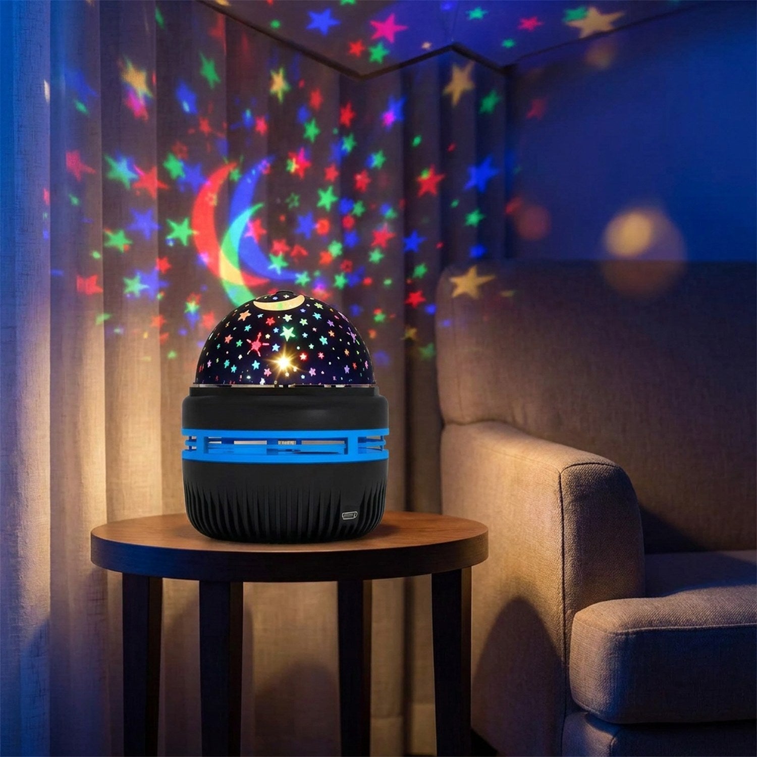 Lampe projecteur étoilé sur une table basse près d'un fauteuil avec projection sur rideaux