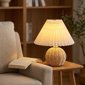 Lampe en rotin allumée sur une table d'appoint près d'un fauteuil dans un coin lecture