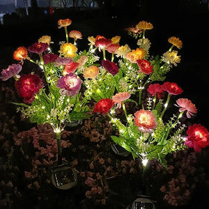 Lampes solaires a fleurs multicolores allumees dans un jardin la nuit