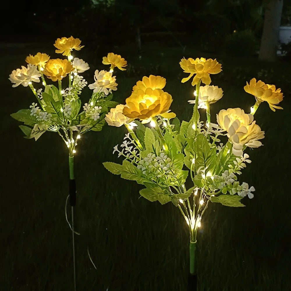 Lampes solaires a fleurs jaunes allumees la nuit dans le jardin
