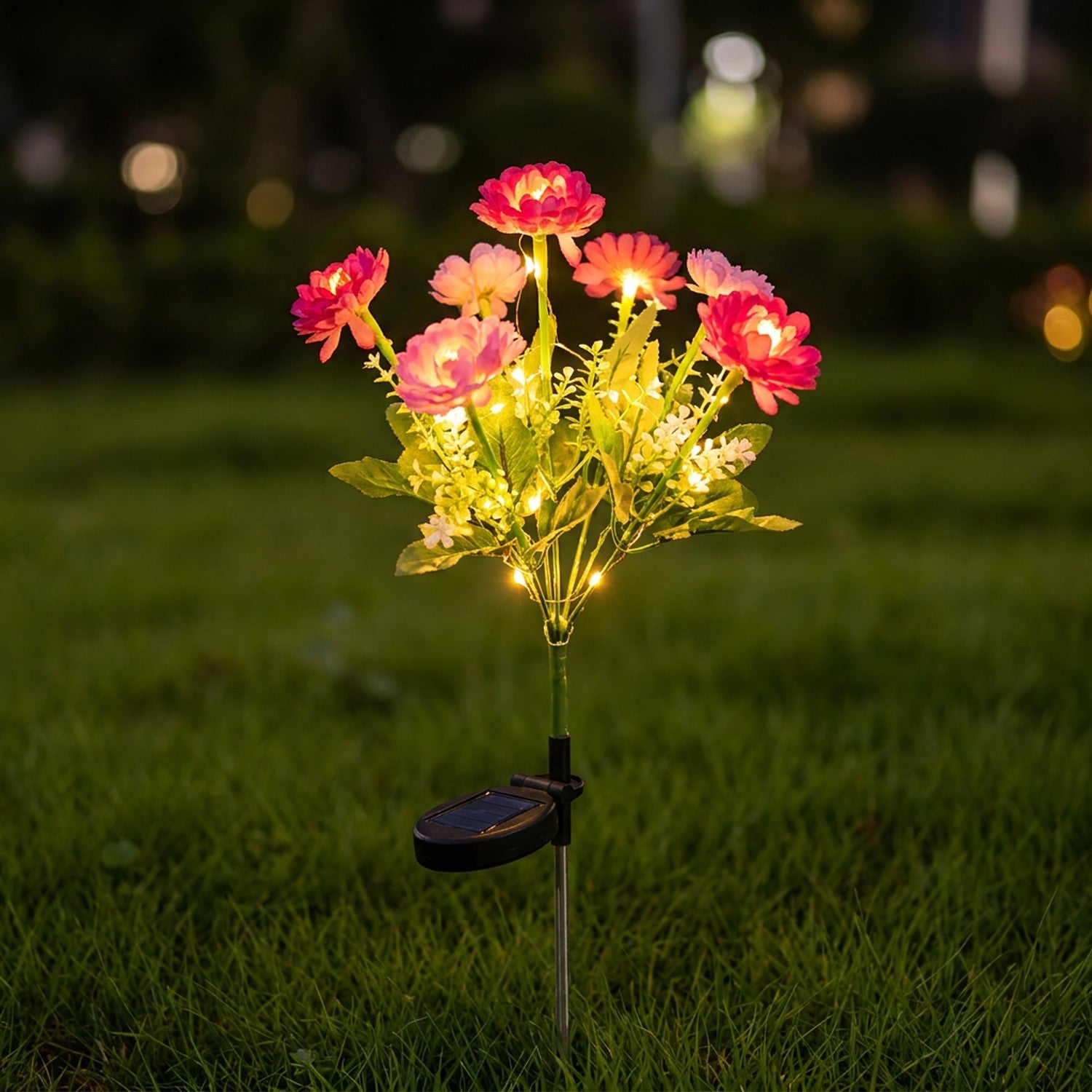 Lampe solaire de jardin a fleurs roses allumee la nuit dans la pelouse
