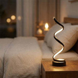 Lampe spirale LED allumée sur une table de chevet près d'un lit