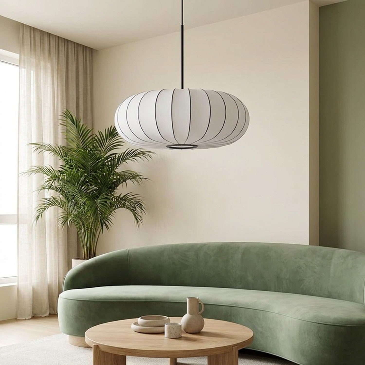 Lampe suspension japonaise soie blanche dans un salon avec canapé vert