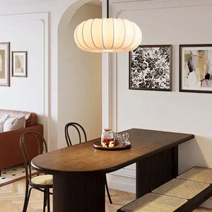 Lampe suspension tambour soie au-dessus d'une table à manger en bois