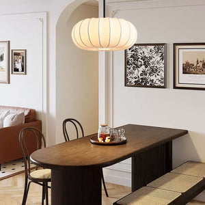 Lampe suspension tambour soie au-dessus d'une table à manger en bois
