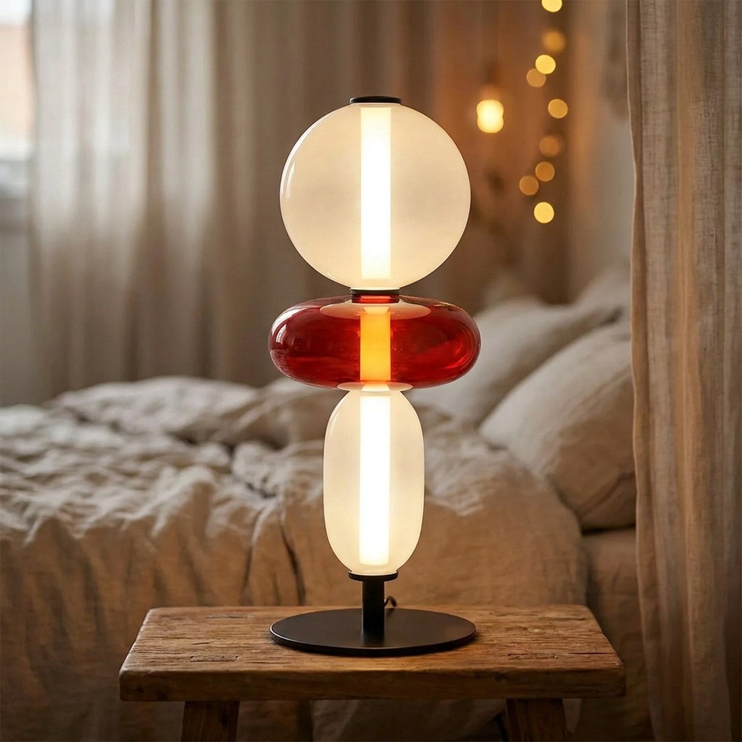 Lampe de table LED 3 globes verre teinté design nordique allumée sur table de chevet