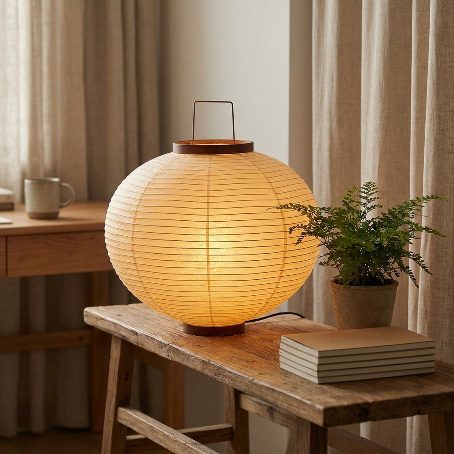Grande lampe de table ronde en papier de riz sur bureau bois, lumière chaude allumée