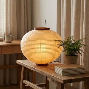Grande lampe de table ronde en papier de riz sur bureau bois, lumière chaude allumée