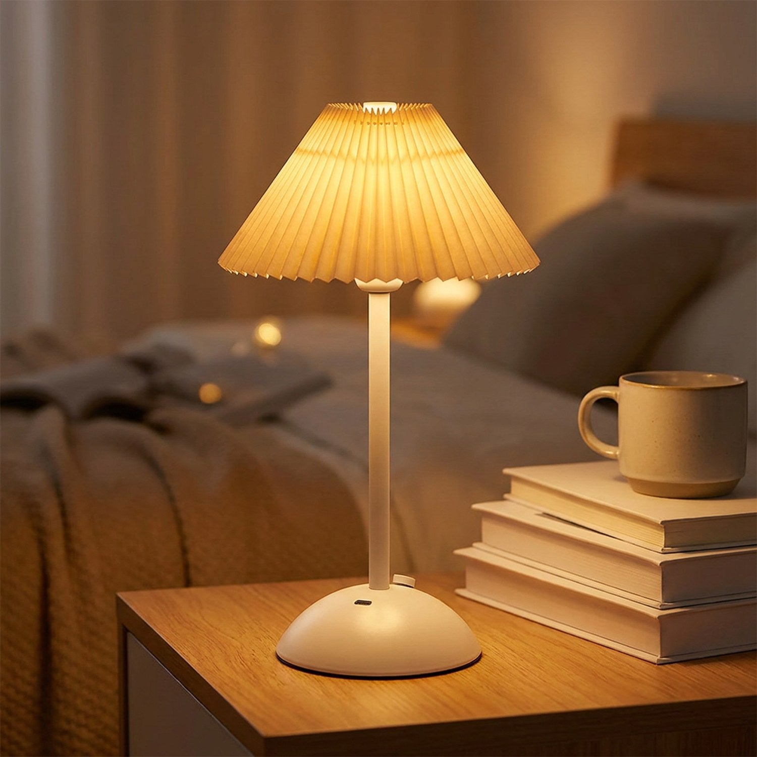 Lampe de table sans fil avec abat-jour plissé beige crème allumée sur une table de nuit