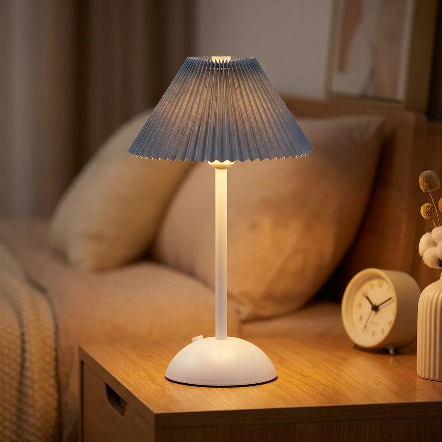 Lampe de table sans fil avec abat-jour plissé bleu allumée sur une table de nuit