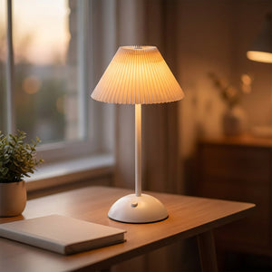 Lampe de table sans fil allumée sur un bureau en bois près dune fenêtre au crépuscule