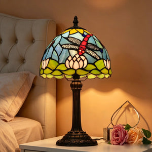 Lampe vitrail Tiffany libellule posée sur une table de chevet chambre