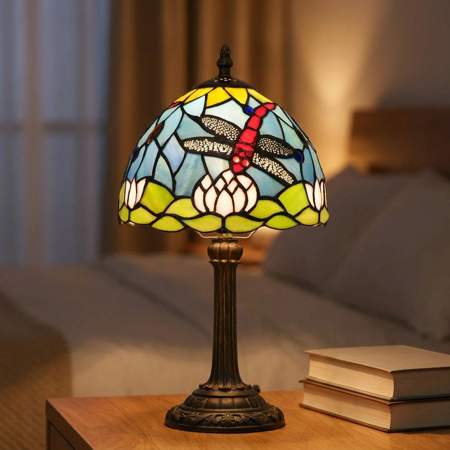 Lampe de chevet vitrail Tiffany libellule allumée sur une table de nuit en bois