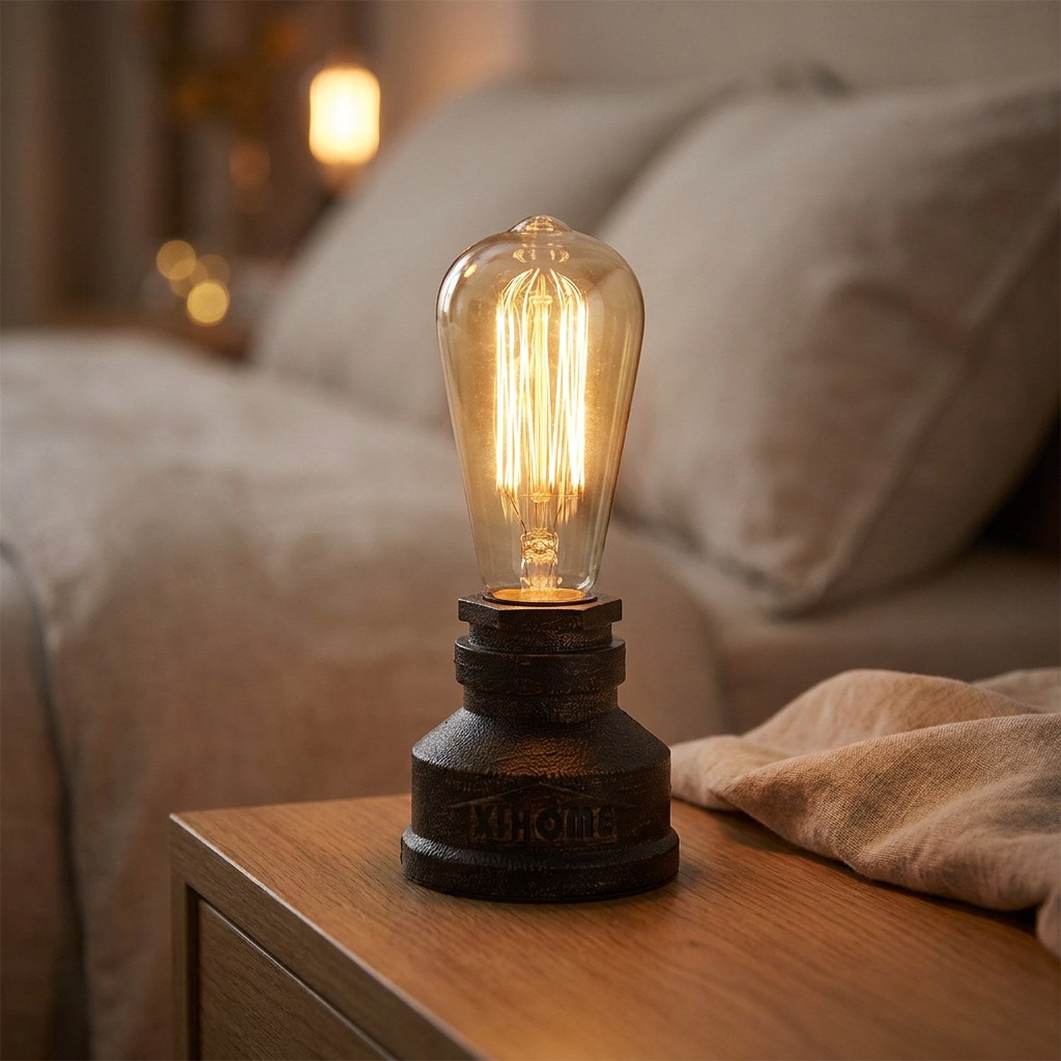 Lampe tuyau industrielle en fer bronze patiné allumée posée sur une table en bois