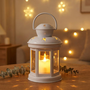 Lanterne étoile photophore blanche allumée posée sur une table en bois avec une lumière chaude