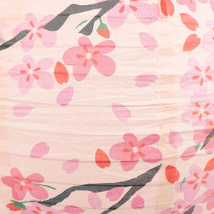 Détail des motifs fleurs de pêcher et branches sur la lanterne en papier rose