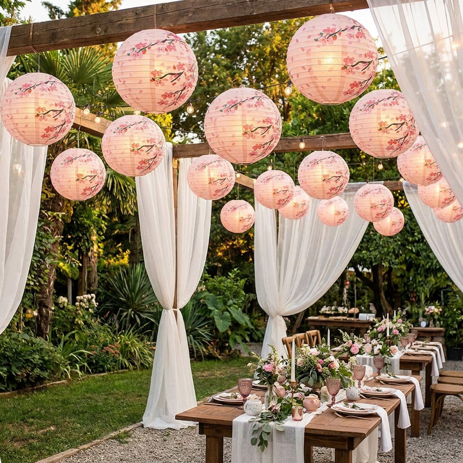 Lanternes japonaises en papier sakura suspendues sous une pergola lors d un mariage en jardin