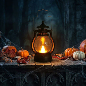Lanterne LED rétro illuminant une décoration d'Halloween avec citrouilles et bougies