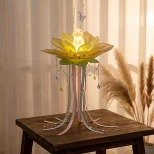 Lanterne lotus jaune posée sur une table en bois près d'une fenêtre voilée