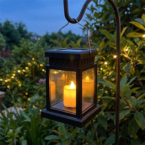 Lanterne solaire d extérieur noire allumée suspendue dans un jardin la nuit