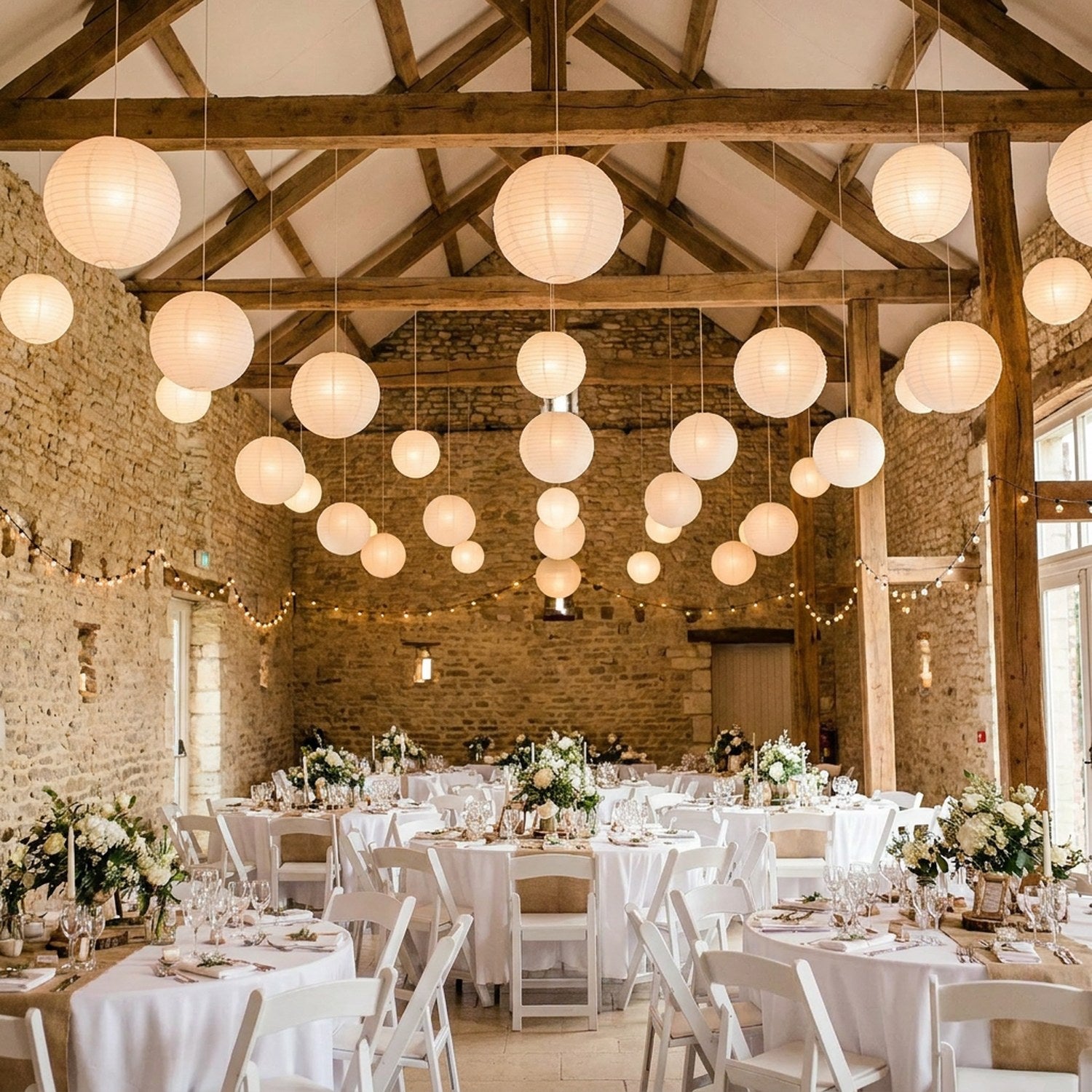 Lanternes papier blanc suspendues décoration mariage grange pierre