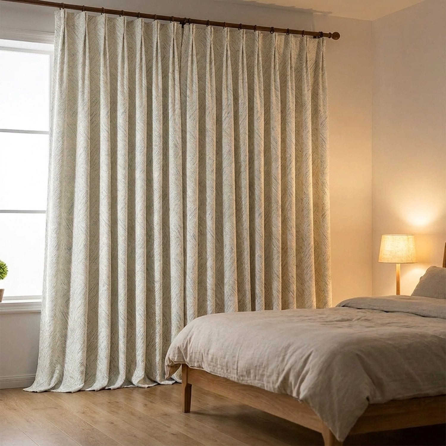 Rideau chenille blanc suspendu dans une chambre cocooning avec lampe de chevet allumée