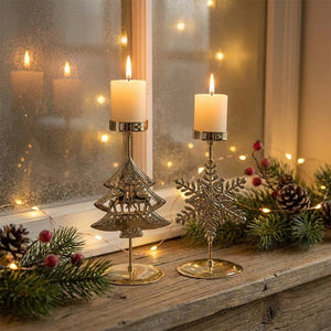 Deux chandeliers de Noël dorés sapin et flocon sur un rebord de fenêtre givrée