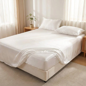 Drap-housse satin blanc élastique sur un lit dans une chambre lumineuse