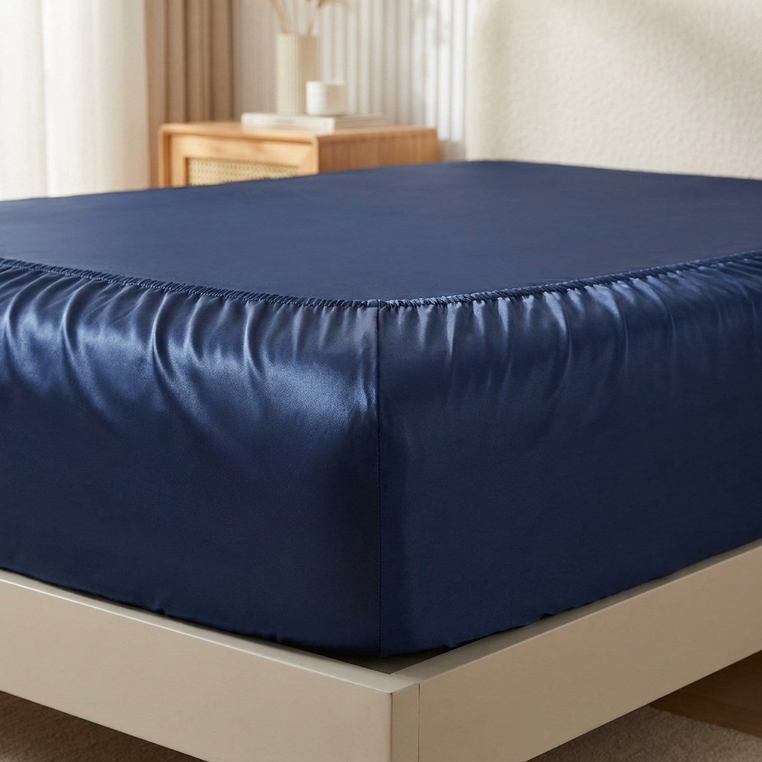 Détail de l'élastique du drap-housse satin bleu marine sur le coin du matelas