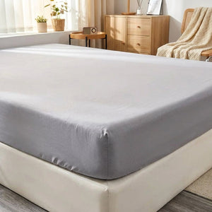 Détail de l'élastique du drap-housse gris satin sur le coin du matelas