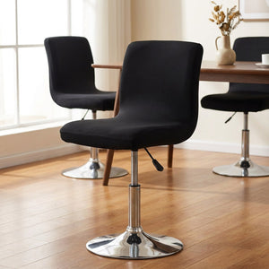 Housses de chaise noires sur des chaises pivotantes autour d'une table à manger